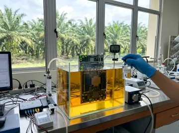Эксперимент по охлаждению электроники в пальмовом масле Sawit EcoTherm в лаборатории на фоне плантации