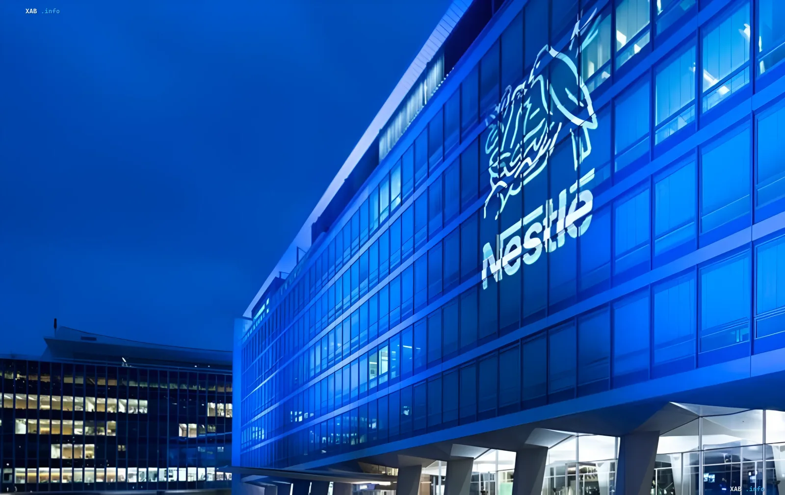 Hauptsitzgebäude von Nestle mit Logo an der Fassade bei Nacht, das das Thema der Übertragung der Vermögenswerte des Unternehmens in eine vorläufige Verwaltung in Russland veranschaulicht
