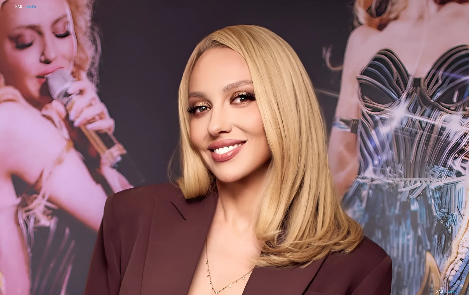 Olya Polyakova in front of her concert poster, smiling after a scandalous interview and filing a lawsuit against a journalist