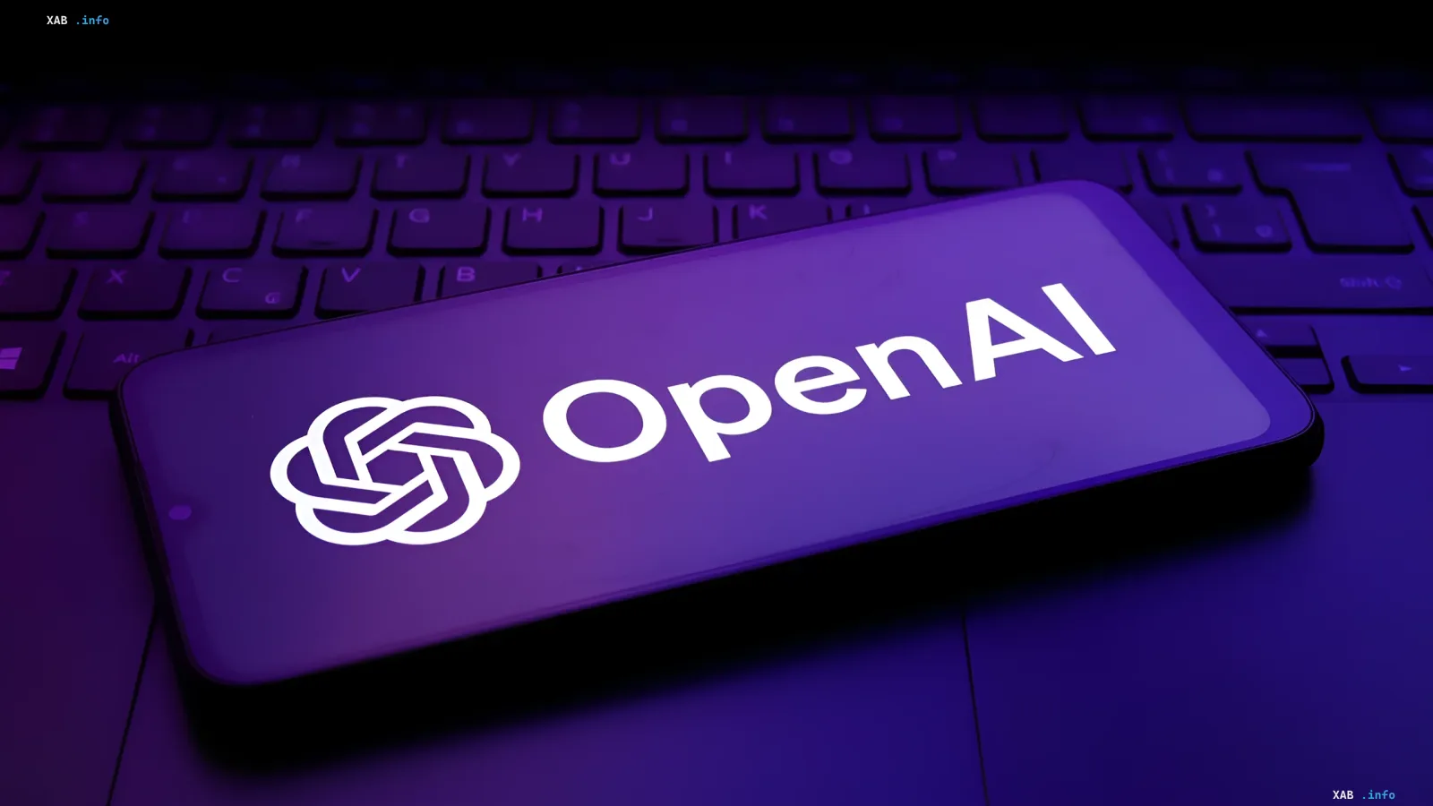 Логотип OpenAI на экране смартфона на фоне клавиатуры ноутбука в фиолетовом освещении, символизирующий закрытие команды Preparedness и оценку рисков ИИ