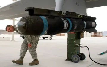 US-Luftwaffensoldat untersucht eine Rakete, die am Flügel eines Jagdflugzeugs montiert ist, im Kontext der Überprüfung der Strategie des Pentagon zur Verlagerung von Basen aus der Reichweite iranischer Raketen.