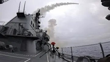 Start einer Tomahawk-Kreuzrakete von einem Kriegsschiff vor einem Hintergrund aus Rauch und Wolken