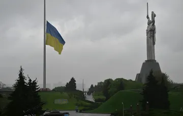 Флаг Украины приспущен на пол-флага в Киеве на фоне памятника Родина-мать из-за штормового предупреждения