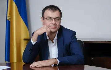 Minister of Economy of Ukraine in office with country flag in background, discussing business support measures