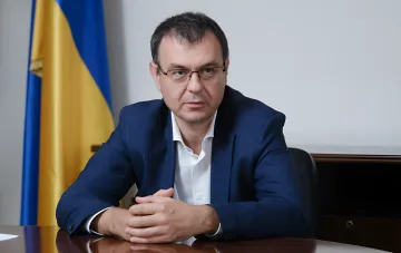 Alexey Gетьманцев am Tisch mit der ukrainischen Flagge im Hintergrund – Diskussion über die Krise des ukrainischen Geschäfts und Konflikt mit der Nationalbank