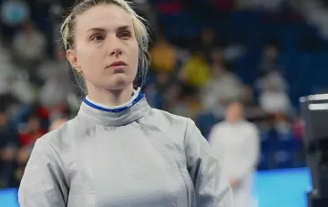 Украинская фехтовальщица Ольга Харлан в форме во время соревнований, взгляд направлен в будущее