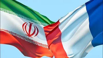 Flaggen von Iran und Frankreich vor einem klaren Himmel, die die diplomatische Krise zwischen den beiden Ländern symbolisieren