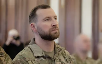 Євген Хмара в військовій формі на фоні офіційної події