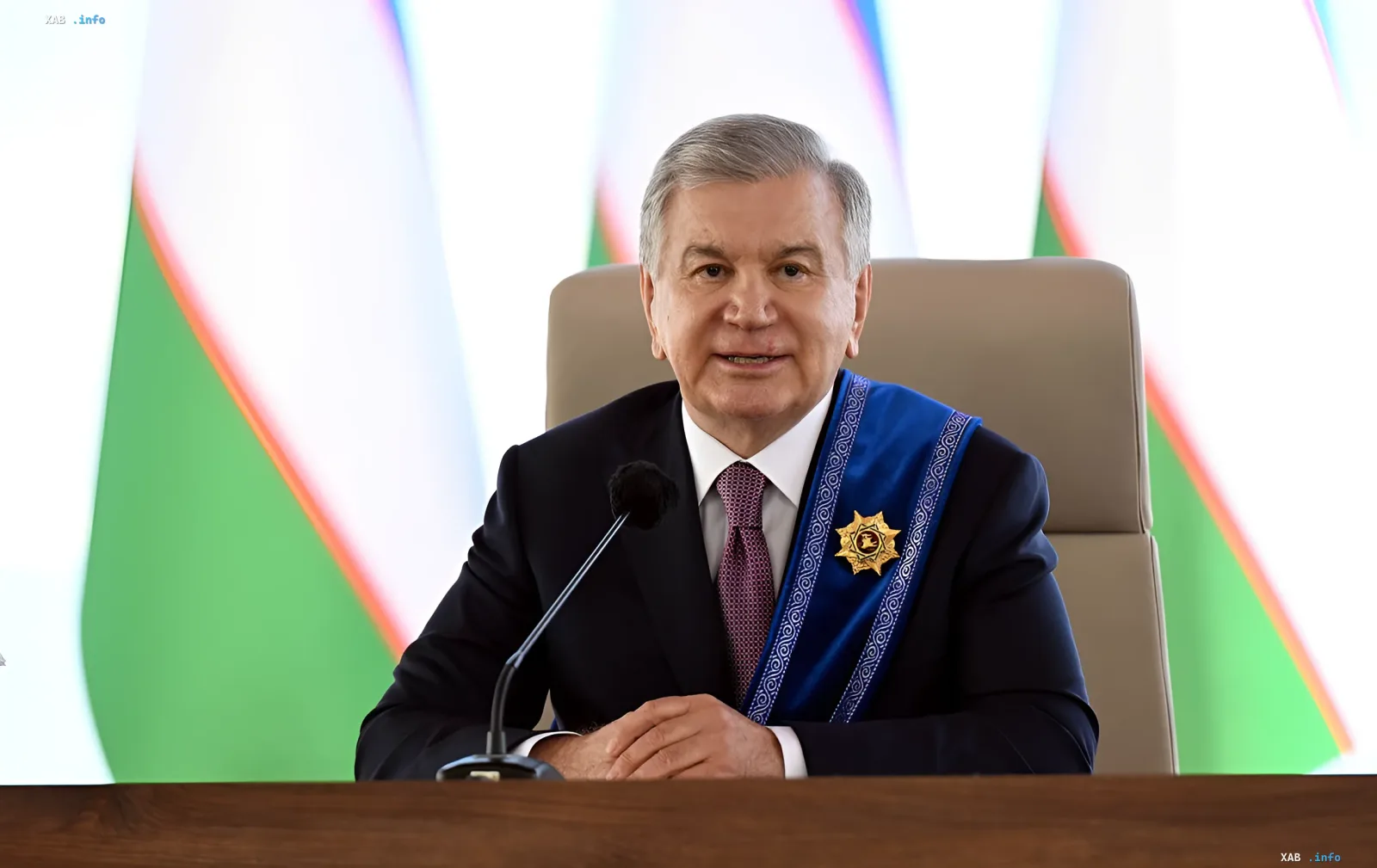 Президент Кыргызстана Садыр Жапаров в официальной обстановке с президентским жезлом на фоне государственных флагов — иллюстрация к новости о ликвидации 19 фирм за обход санкций ЕС и США