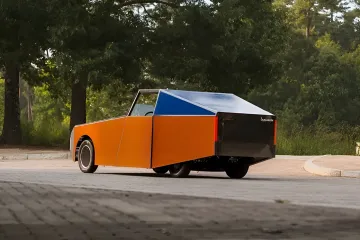 Прототип BMW Luminetta с оранжевым кузовом и синей солнечной панелью на крыше, демонстрирующий концепцию энергонезависимого автомобиля