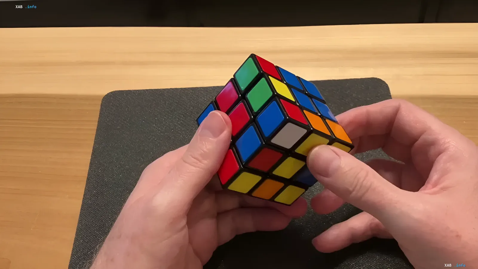 Руки спидкубера держат перемешанный кубик Рубика 3x3 во время решения вслепую — новый мировой рекорд Томми Черри 11,56 секунды