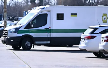 Бронированный инкассаторский фургон Ощадбанка с зеленой полосой и логотипом, стоящий на парковке — символ «золотого конвоя», по которому Венгрия закрыла дело