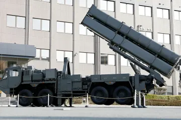 Японская пусковая установка гиперзвуковой ракеты на фоне здания, демонстрирующая военную технику для испытаний в Австралии