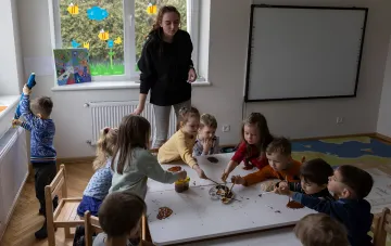 Воспитательница с детьми в детском саду: иллюстрация к новости о возможном росте зарплат педагогов в Украине на 20% с 2027 года