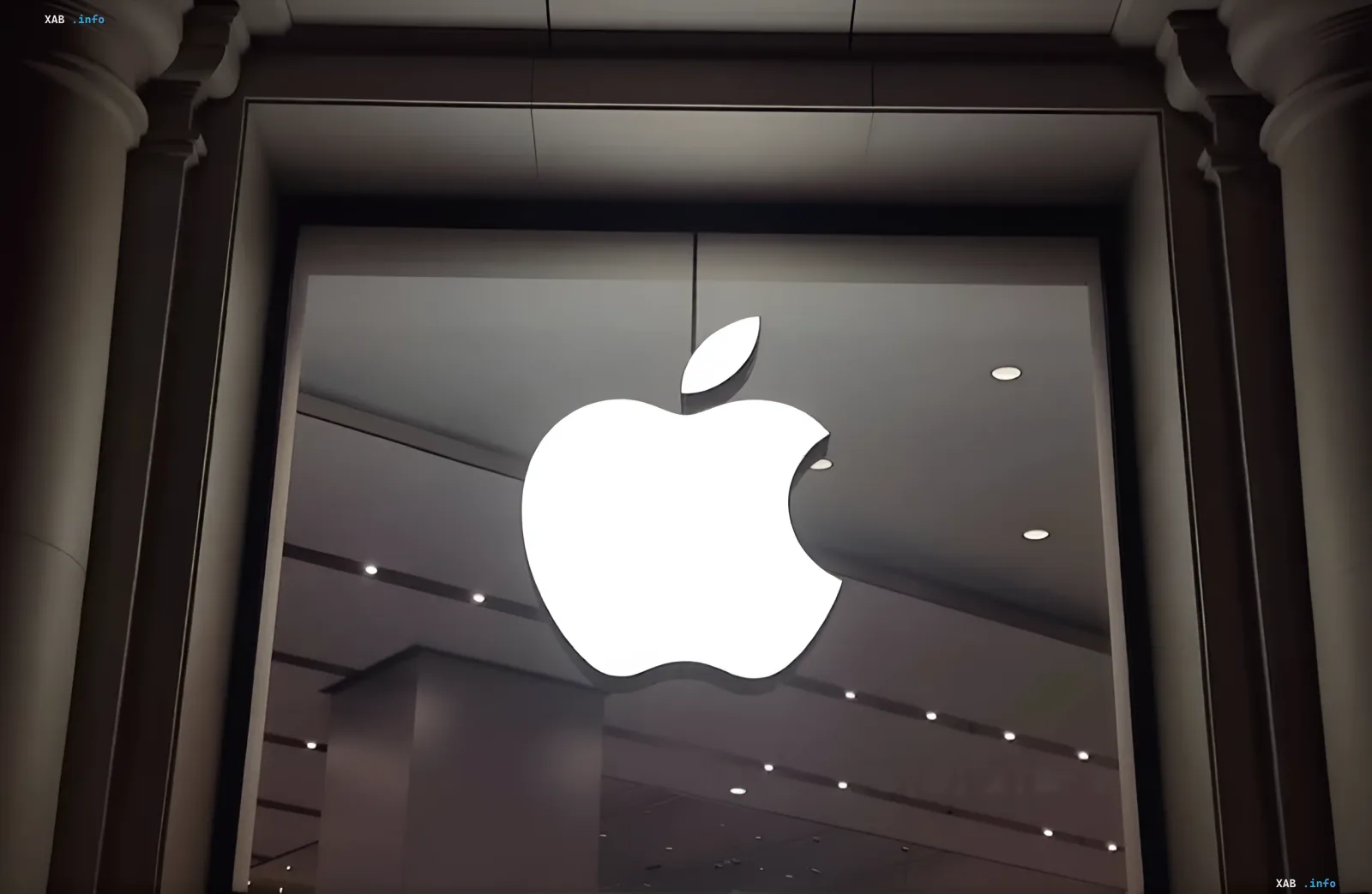 Светящийся логотип Apple на витрине магазина на фоне новости об утечке из беты macOS 26.7, раскрывшей умный дисплей HomePad с циферблатами
