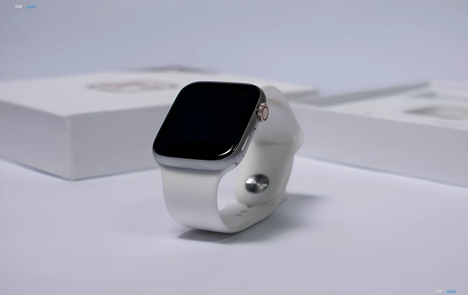 Apple Watch Series 12 с премиальным светлым керамическим корпусом и белым ремешком на фоне фирменной упаковки