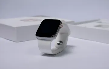 Apple Watch Series 12 с премиальным светлым керамическим корпусом и белым ремешком на фоне фирменной упаковки
