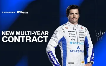 Карлос Сайнс в белой гоночной форме Williams F1 Team с логотипами Atlassian и спонсоров на фоне надписи NEW MULTI-YEAR CONTRACT о подписании нового многолетнего контракта