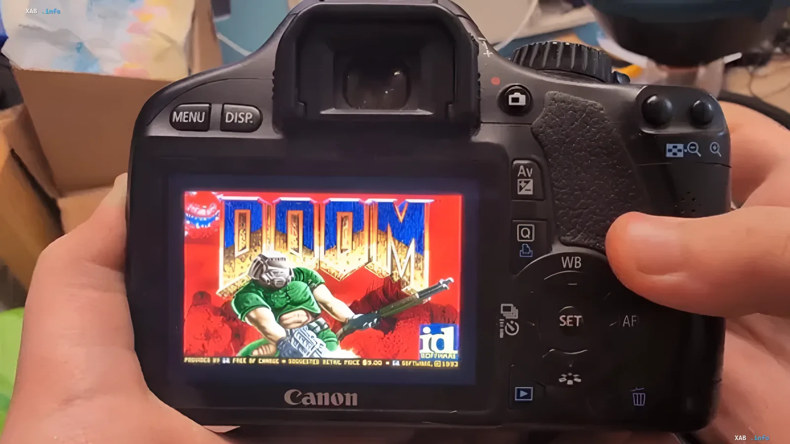 Doom-Spiel auf dem LCD-Bildschirm einer Canon EOS 550D Spiegelreflexkamera, die in beiden Händen gehalten wird