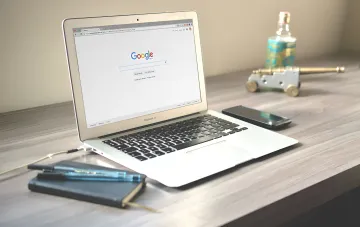 Laptop mit geöffnetem Google-Startbildschirm und Gemini auf dem Schreibtisch: Nutzer erkundet 3D-Modelle und interaktive Diagramme im neuen Lernmodus
