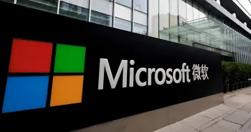 Логотип Microsoft с китайской надписью 微软 на фоне офиса компании — Пекин приказал госучреждениям удалить модифицированную версию Windows 10