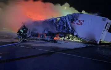Feuerwehrleute löschen einen brennenden Lastwagen mit Lebensmitteln nach einem nächtlichen Angriff auf den Süden der Oblast Odessa, Flammen und Rauch auf der Straße