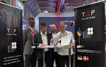 Подписание соглашения о совместном производстве FPV-дронов между TAF Industries и датской Upteko на выставке, флаги Украины и Дании