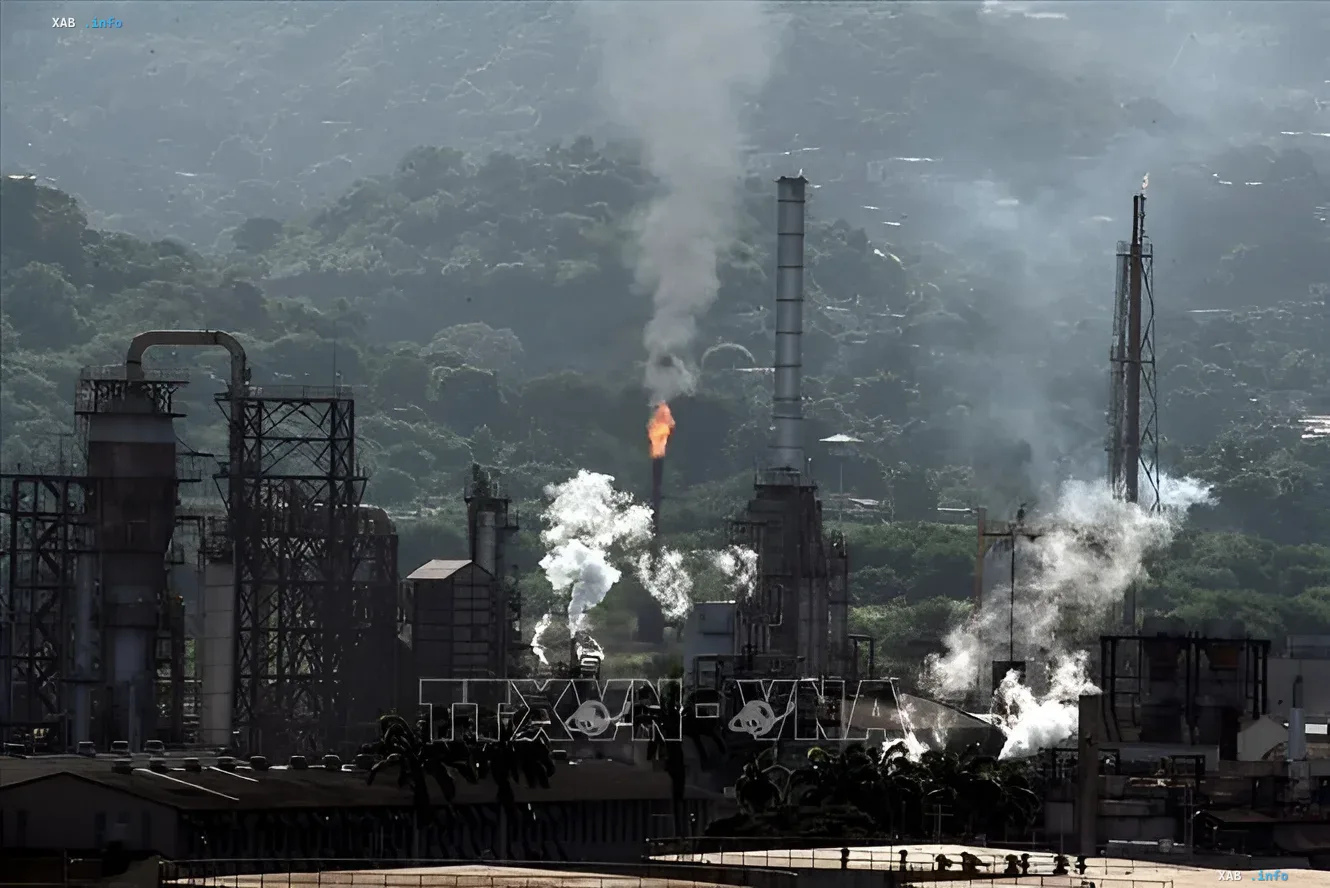 Ölraffinerie-Komplex in Venezuela mit Flare und Schornsteinen vor Hügeln — Kontext der Verträge mit Hunt Oil und SLB zur Erkundung des Carito-Felds