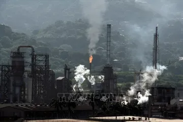Ölraffinerie-Komplex in Venezuela mit Flare und Schornsteinen vor Hügeln — Kontext der Verträge mit Hunt Oil und SLB zur Erkundung des Carito-Felds