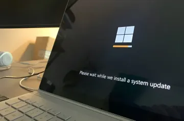 Ноутбук с экраном установки обновления Windows в фоне инцидента ShieldBreak, когда патч Microsoft сломал сканирование Windows Defender