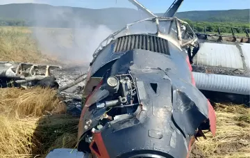 Обгоревший фюзеляж самолёта Ан-3 после аварийной посадки и пожара в поле на Сахалине, дым от обломков