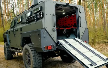Gepanzertes Sanitätsfahrzeug der ukrainischen Streitkräfte mit offenem Heckrampen und Trage zur Evakuierung Verwundeter im Wald
