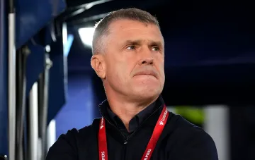 Dmytro Rebrov auf der Stadiontribüne mit European-Qualifiers-Badge, der sich für ein Padel-Spiel mit Berezutsky entschuldigte