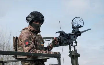 Оператор ПВО Украины за зенитным пулемётом на фоне ночной атаки 135 дронов РФ