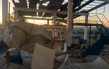 Разрушенное здание пограничного перехода Табаки после атаки БПЛА: повреждённая крыша, обломки и вырванные панели на закате