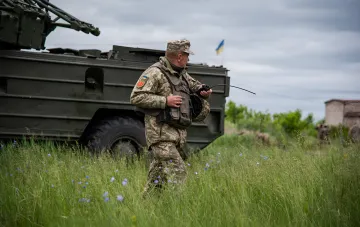 Боец ВСУ с рацией у бронетехники в зоне продвижения к югу от Доброполья в районе Водяного