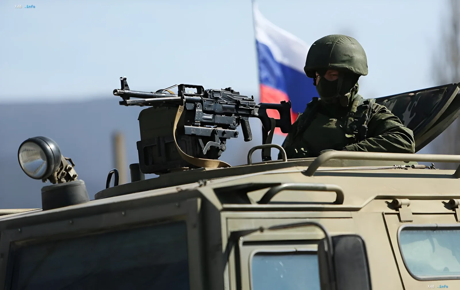 Российский военный с пулемётом на бронемашины на фоне российского флага в Крыму на фоне ночных ударов по полуострову