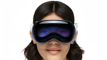 Женщина в гарнитуре Apple Vision Pro на фоне новостей о сокращении сотрудников в командах Vision Pro и Siri