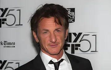 Sean Penn in a black suit against the backdrop of the 51st New York Film Festival NYFF 51 logos, producer of the documentary 'Black Sunflowers' about Ukrainian youth coming of age during the war