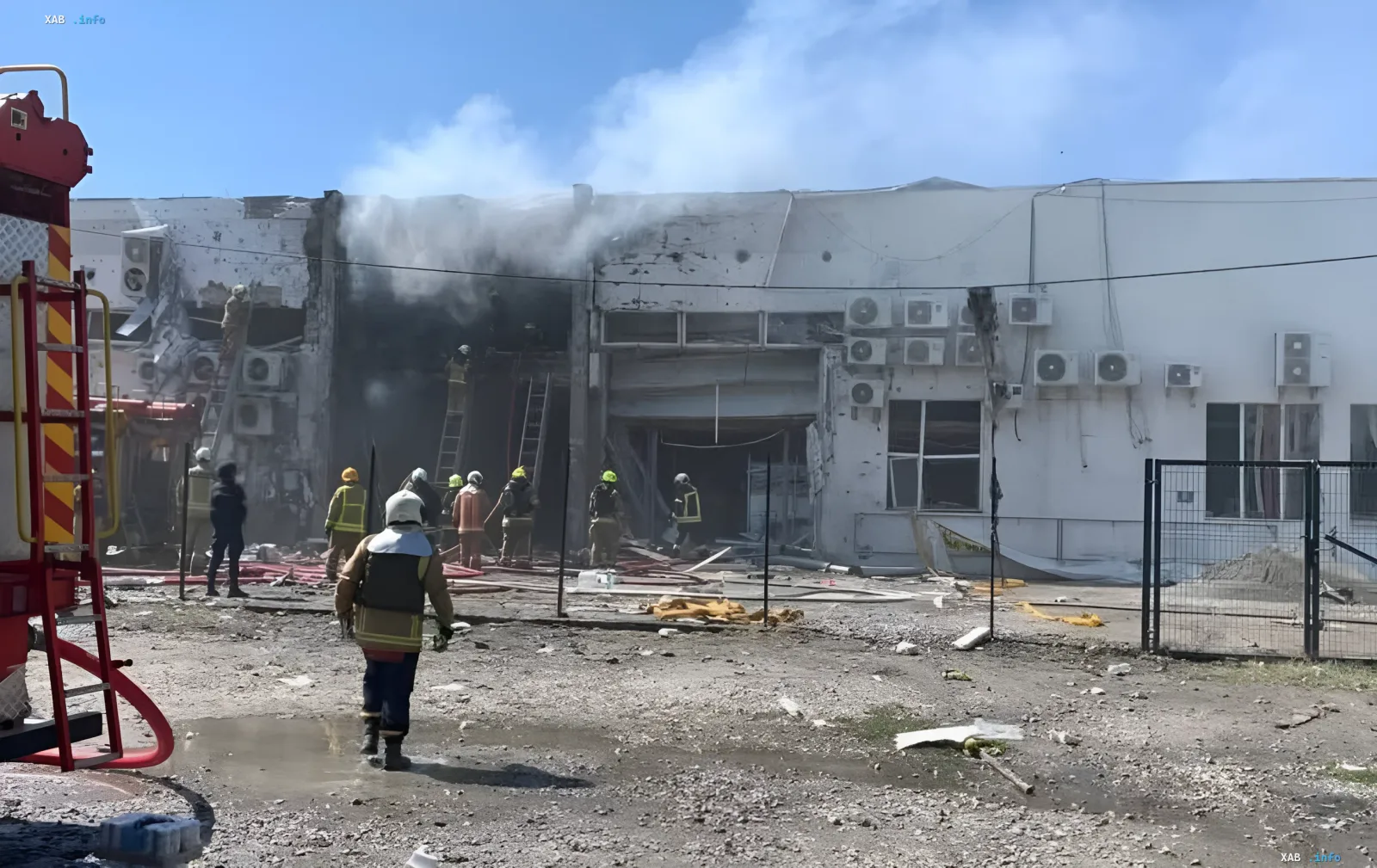 Firefighters work at the distribution center 'Aurora' after a repeated Russian strike: smoke rises from breaches in the wall amid the wreckage
