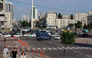 Traffic restrictions in central Kyiv: road barriers and cones on a busy street with buses, taxis and a police van ahead of foreign delegation visits