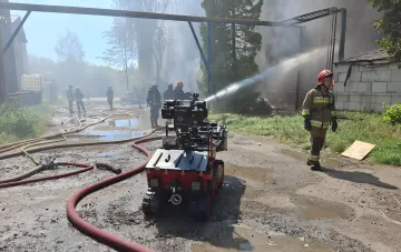 A tracked firefighting robot and emergency responders extinguish a fire at the Iskra factory in Lviv, Ukraine
