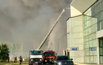 Пожар в торговом центре JYSK после удара: пожарные тушат здание, густой дым поднимается в небо