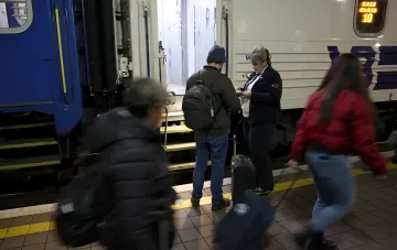 Ukrzaliznytsia staff member checking a passenger's documents at a station, illustrating the data collection process under the new privacy policy