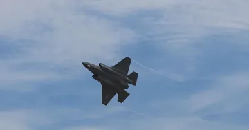 Истребитель F-22 Raptor в полёте на фоне облачного неба — потенциальный носитель новой ракеты AIM-424 Malice