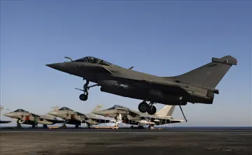 Бойовий літак Rafale злітає з палуби авіаносця на тлі інших бойових літаків