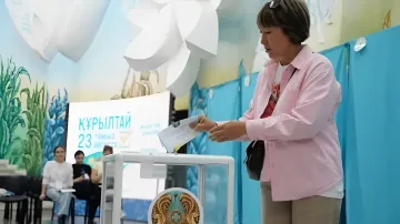 Голосование на выборах в Курултай: избирательница опускает бюллетень в урну