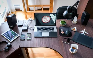 A modern home office desk with a laptop, tablet and smartphones — consumer electronics that outperform the Apollo 11 computer