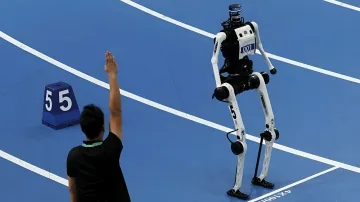 Chinese running robot Tiangong Ultra at the start of a 100-meter race, referee raises hand to signal the start