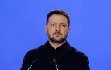 Владимир Зеленский выступает на фоне синего экрана во время заявления о производстве Россией баллистических ракет